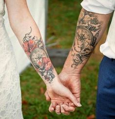 two people holding hands with tattoos on their arms and the other hand has a clock