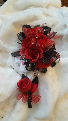 the bridal bouquet has red roses and black ribbons on it's headband