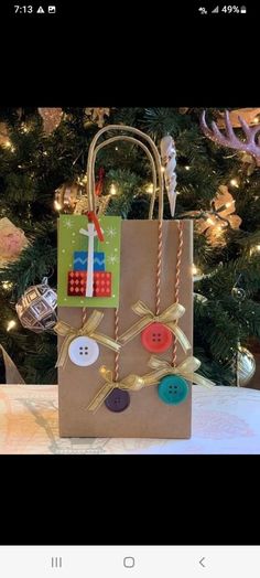 a small brown bag with buttons on it and a christmas tree in the back ground