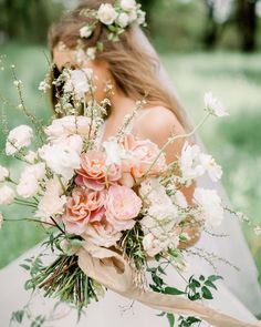 a bride holding a bouquet of pink and white flowers