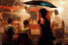 a blurry photo of people standing under an umbrella