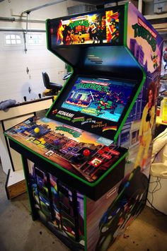 a video game machine sitting inside of a room next to a table with several games on it