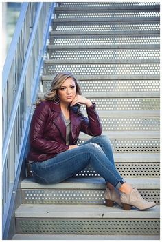 a woman sitting on some steps with her hand on her chin