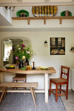 a dining room table with two chairs and a bench