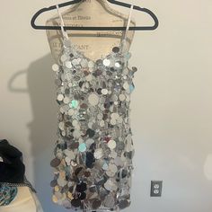 a dress hanging on a hanger next to a mannequin