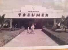 an old black and white photo shows two people standing in front of a building with the word tocumen on it