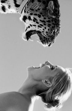 a woman with her mouth open looking up at a cheetah