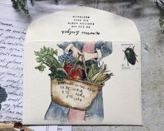 an envelope with a drawing of a woman holding a bag full of vegetables