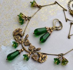 "VINTAGE ELEMENTS Unique Jewellery, Handmade from Vintage Inspired Original Designs Ethereal, Art Nouveau Style, antiqued brass Necklace and Earring set with Emerald Green, Czech glass drops, and Czech glass Bell Flower beads in corresponding tones. The Necklace, made with antiqued brass bar chain measures 17\" (43cm)   in length plus a 3\" (8cm) extender chain. The earrings have antiqued brass leverback earwires and matching  Emerald Green Teardrops. They measure 4.9cm from the top of  the earw Bijoux Art Nouveau, Art Nouveau Antiques, Art Nouveau Jewelry, Green Jewelry, Floral Necklace, Fantasy Jewelry, Dream Jewelry, Jewelry Inspo, Pretty Jewellery