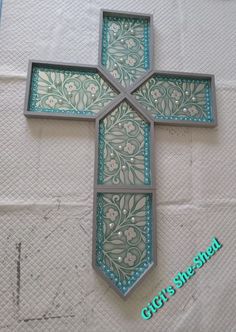 the cross is made out of metal and has blue glass inlays on it