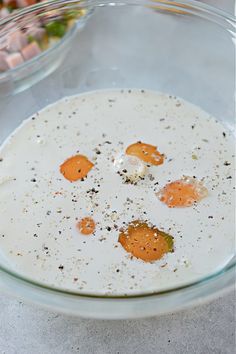 three eggs in a bowl with seasoning on top and other ingredients around them to make an appetizer