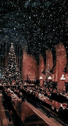 people sitting at tables in a church with christmas decorations on the ceiling and lights hanging from the ceiling