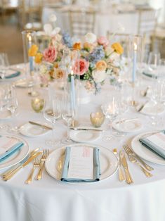 the table is set with silverware, plates and napkins for an elegant wedding reception