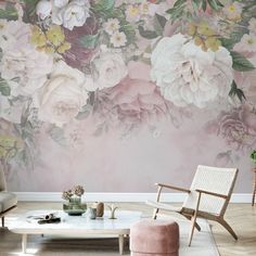 a living room with pink flowers on the wall and a white coffee table in front of it