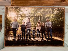 a family portrait is displayed on a wooden plank