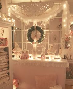 a room filled with christmas decorations and lights on the window sill above a couch