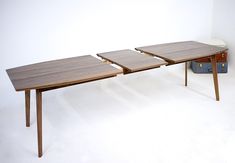 three wooden tables sitting next to each other on top of a white floored room