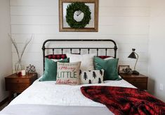 a bed with pillows and blankets on top of it in a room that has white walls