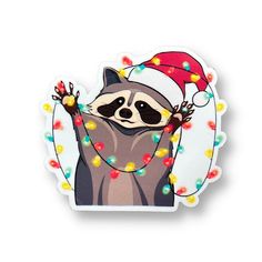 a raccoon wearing a santa hat and lights around its neck, with his arms in the air