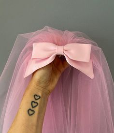 a woman's arm with a pink tulle and a tattoo on the wrist