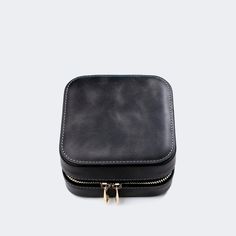 a black leather case with gold zippers on the front and side, sitting against a white background