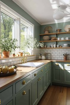 a kitchen filled with lots of green cupboards and counter top next to a window