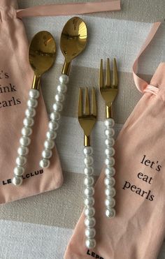 three forks and two spoons with pearls on them