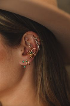 a close up of a person wearing a hat with ear piercings on their ears