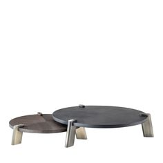 two circular tables with metal legs on each side, one is black and the other is grey