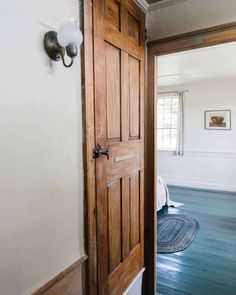 an open wooden door in a white room