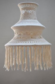 a white chandelier with fringes hanging from it's sides on a gray wall