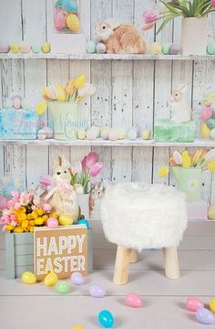 there is a white sheep sitting on a stool next to some flowers and easter eggs