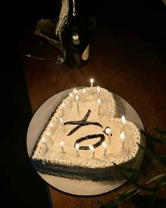 a cake with candles in the shape of an x on it sitting on a table