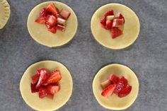 four small pies with strawberries on them