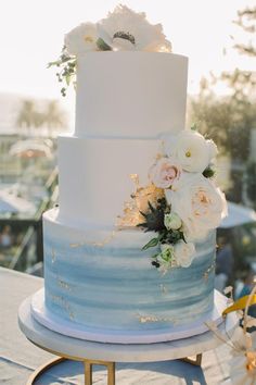 a white and blue wedding cake sitting on top of a table