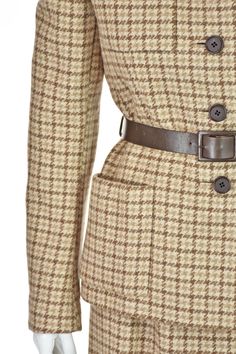 This is a very rare, vintage skirt suit from acclaimed American designer Norman Norell (1900-1972). The union label in this suit was used from 1963-1974, placing it in the mid to late 1960s. The five-button jacket has no collar, four patch pockets, a leather belt, buttoned cuffs, and is lined in silk taffeta. The skirt has a few gathers on each side of the front waistband, making it slighter fuller than a "pencil" skirt. The fabric is a heavy wool houndstooth plaid in varying shades of taupe, ivory and brown. Both pieces are lined in silk taffeta, most of which has been sewn in by hand, as have been the pockets. Based on the measurements, we are estimating it to be about a size 6 or 8. Please refer to the measurements for additional guidance regarding size. JACKET MEAUREMENTS- Shoulder wid Norman Norell, Vintage Skirt Suit, Four Patch, Belted Skirt, Garment Workers, Silk Taffeta, Skirt Belt, The Union, American Design