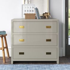 a white dresser with gold handles in a room