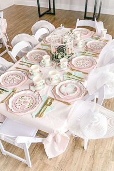 the table is set with pink and white plates