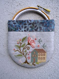 a close up of a small bag on the ground with flowers and a house painted on it