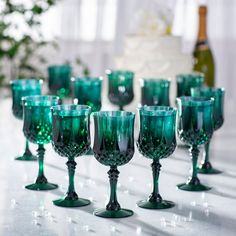 many green wine goblets lined up on a table