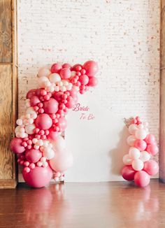 the balloon arch is decorated with pink and white balloons