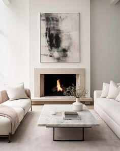 a living room with white furniture and a fire place