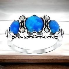 Discover the enchanting allure of our Vintage Blue Lab-created Fire Opal Ring with Freshwater Pearl, crafted in 925 Sterling Silver. This stunning piece features a captivating blue fire opal as the centerpiece, flanked by elegant pearls--a perfect blend of color and elegance. Ideal for October birthdays, anniversaries, or special occasions, this three-stone ring stands out as a thoughtful gift or personal treasure. Handmade with love and authenticity, it embodies timeless beauty and sophistication. Enhance your jewelry collection today with a piece that tells a story! Excellent Condition/Like New. Blue Three Stone Birthstone Ring, Blue Three Stone Round Jewelry, Blue Cabochon Opal Ring, Blue Cabochon Opal Ring For Anniversary, Elegant Blue Opal Ring Stamped 925, Silver Three Stone Opal Ring For Anniversary, Blue Opal Round Ring, Blue Round Opal Ring, Anniversary Blue Cabochon Opal Ring