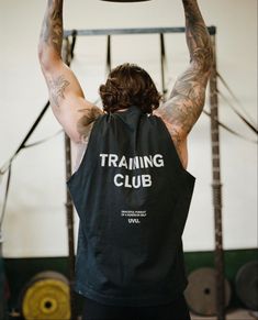 a man with tattoos on his arms is lifting a barbell