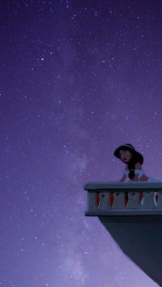 a woman sitting on top of a building under the stars