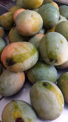 some green and yellow fruit sitting on top of each other with brown spots all over them