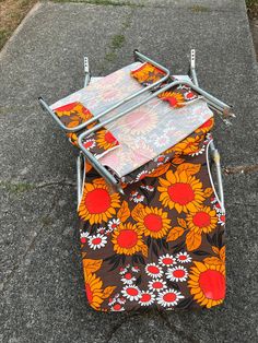 an ironing board on top of a flowered cloth covered chair with metal legs