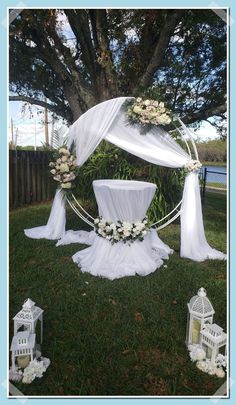 an outdoor wedding setup with white flowers and chairs