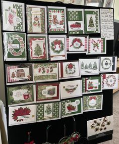 christmas cards are displayed on a wall in front of other greeting cards and decorations for sale