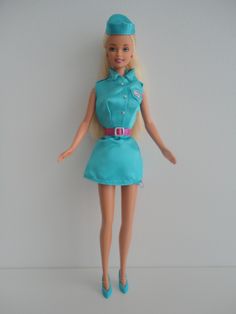 a barbie doll wearing a blue dress and hat